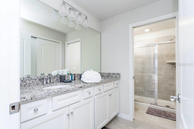 bathroom with walk in shower, tile floors, and vanity