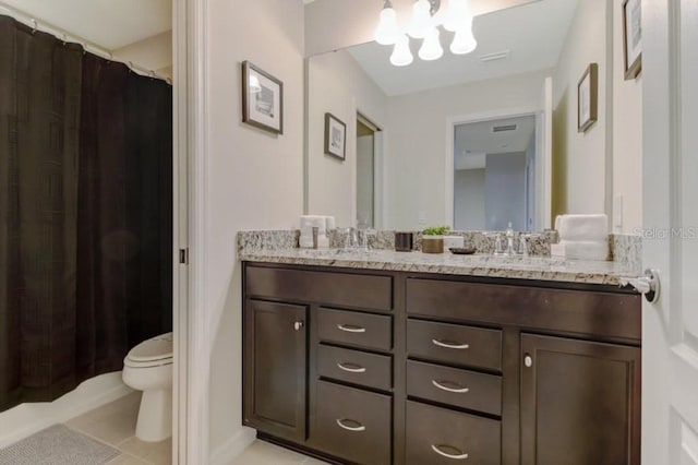 bathroom with tile flooring, large vanity, double sink, a chandelier, and toilet