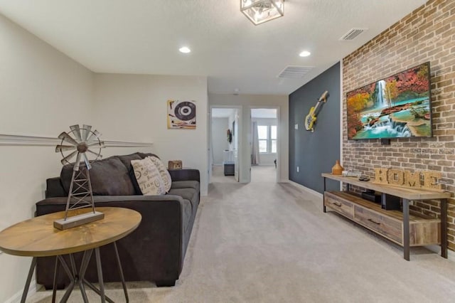 carpeted living room featuring brick wall and a textured ceiling