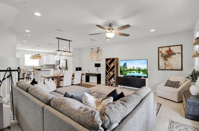 living room with ceiling fan and light tile patterned floors