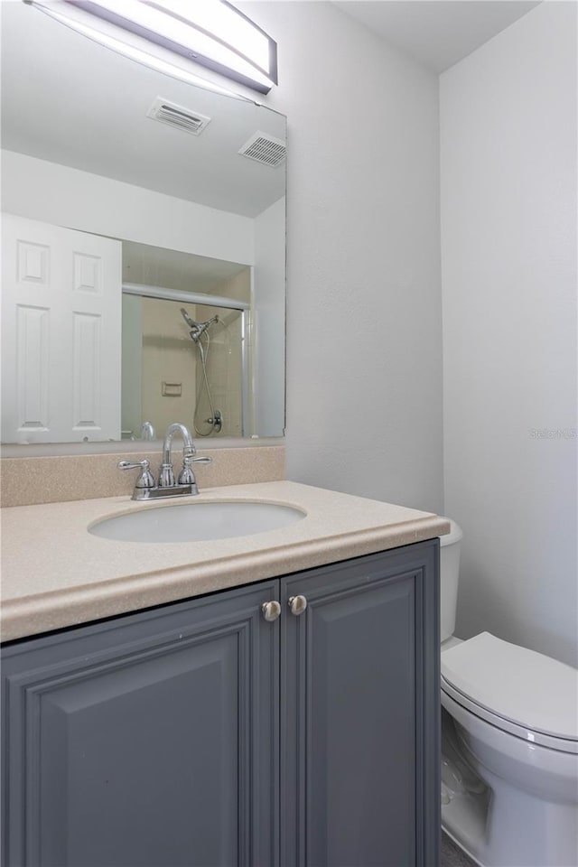 bathroom featuring vanity, toilet, and walk in shower