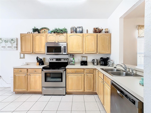 kitchen with sink, light tile floors, and stainless steel appliances