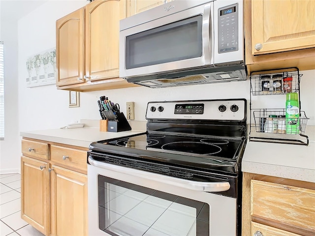 kitchen with appliances with stainless steel finishes, light brown cabinets, and light tile floors