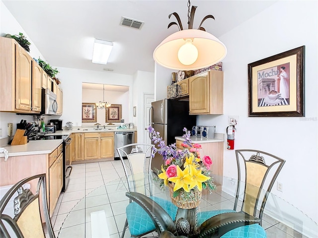 kitchen featuring sink, light brown cabinets, light tile floors, and stainless steel appliances