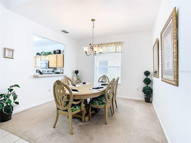 dining area featuring light carpet and a chandelier