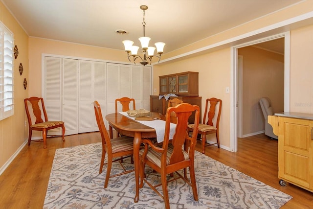 dining area featuring light hardwood / wood-style flooring and a chandelier