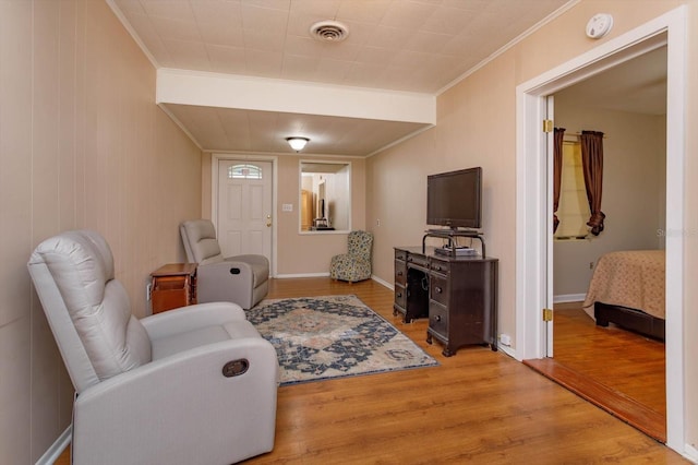 sitting room with crown molding and wood-type flooring