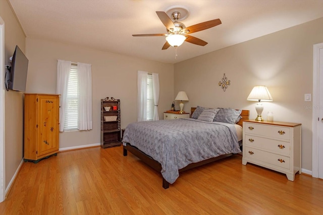 bedroom featuring ceiling fan, light wood-type flooring, and multiple windows