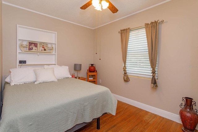 bedroom featuring ceiling fan, crown molding, and hardwood / wood-style flooring