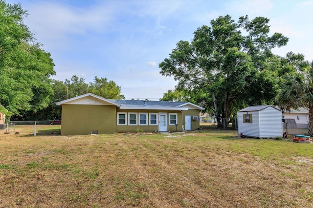 rear view of property with a shed and a lawn