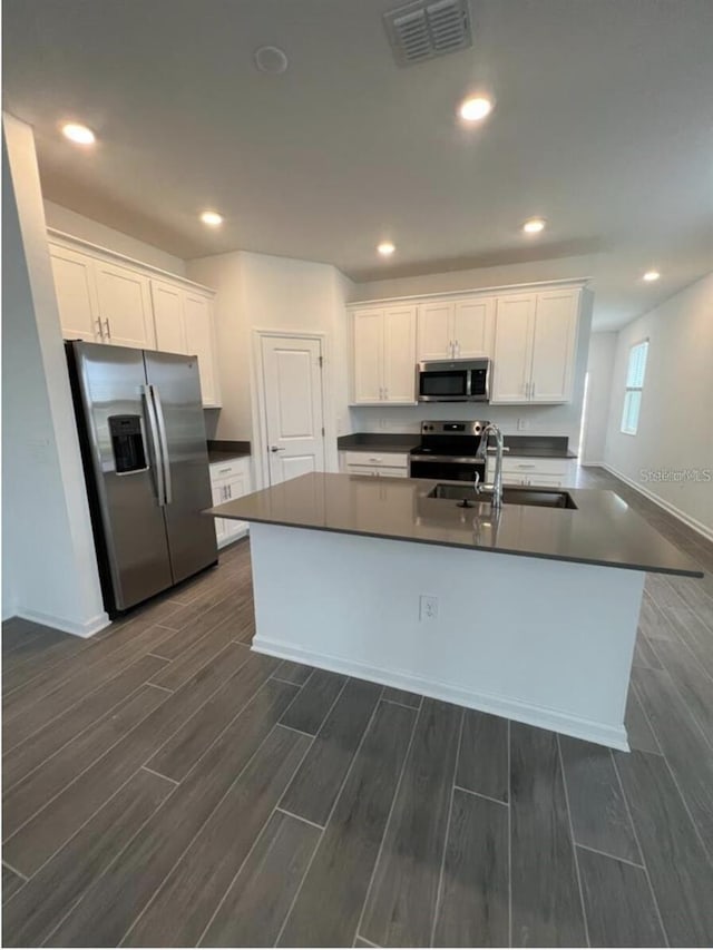 kitchen with white cabinets, sink, stainless steel appliances, and dark hardwood / wood-style flooring