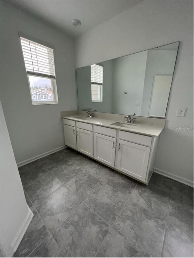 bathroom with tile floors and dual bowl vanity