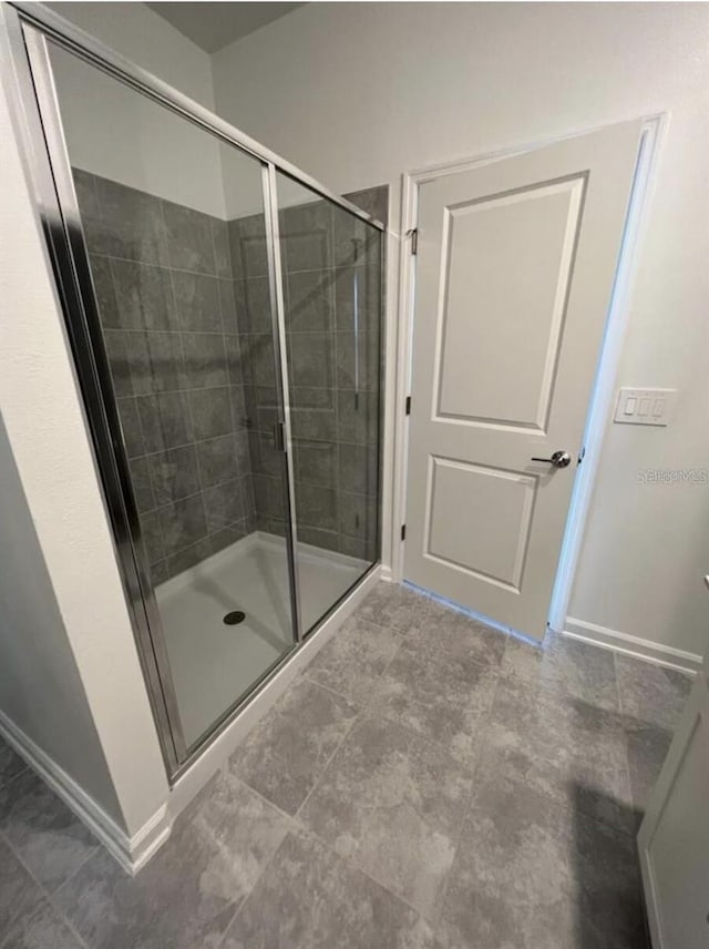 bathroom featuring tile flooring and a shower with shower door