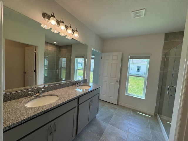 bathroom with tile flooring, double sink, oversized vanity, and a shower with door