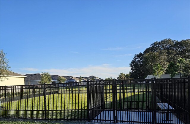 view of gate featuring a yard