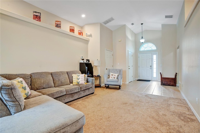 carpeted living room with high vaulted ceiling