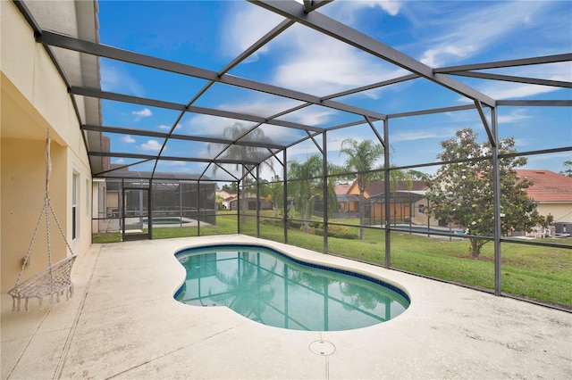 view of swimming pool with a patio area, a yard, and a lanai