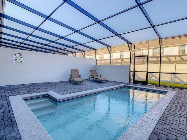 view of swimming pool featuring a patio and a lanai