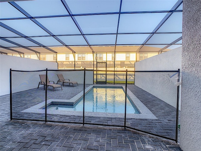 view of swimming pool with glass enclosure and a patio