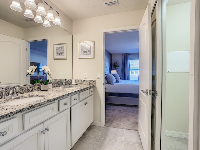 bathroom featuring large vanity, tile flooring, a textured ceiling, double sink, and an inviting chandelier