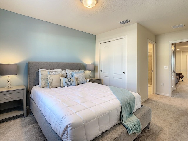 carpeted bedroom featuring a closet and a textured ceiling