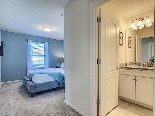 tiled bedroom featuring sink and a textured ceiling