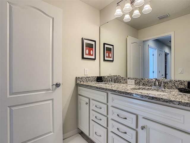 bathroom featuring double vanity and a chandelier