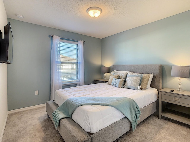 bedroom featuring light colored carpet and a textured ceiling