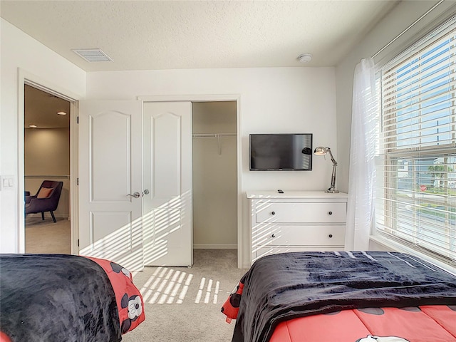 bedroom with a closet and light carpet