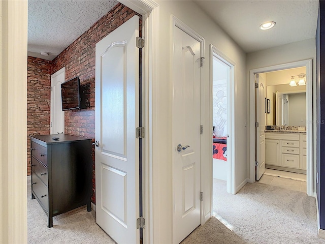 corridor featuring light colored carpet and a textured ceiling