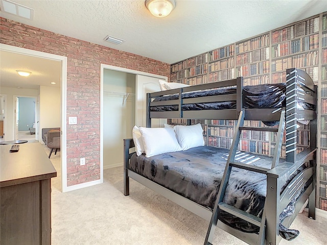 bedroom featuring light colored carpet, a closet, and a textured ceiling