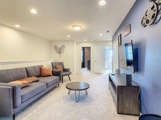 carpeted living room featuring a textured ceiling