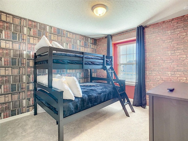 carpeted bedroom featuring brick wall and a textured ceiling