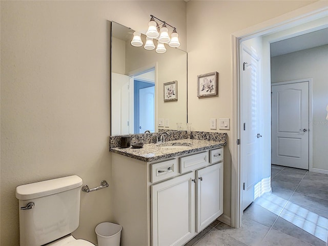 bathroom featuring tile flooring, a notable chandelier, vanity, and toilet