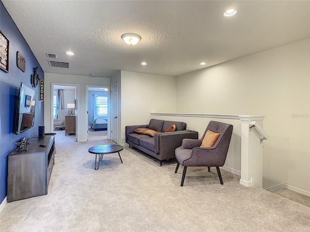 living room featuring light colored carpet and a textured ceiling