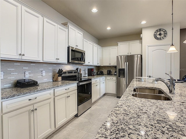 kitchen with tasteful backsplash, stainless steel appliances, light tile floors, and decorative light fixtures