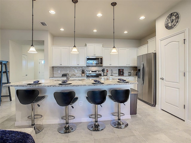 kitchen with white cabinets, pendant lighting, and stainless steel appliances