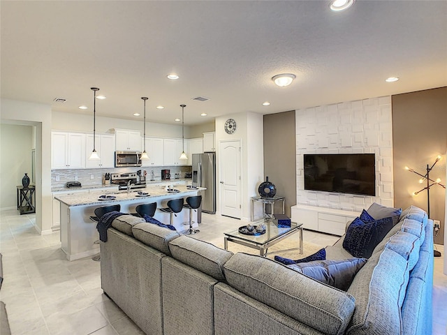 tiled living room featuring a large fireplace