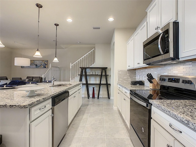 kitchen featuring light tile floors, backsplash, white cabinetry, stainless steel appliances, and pendant lighting