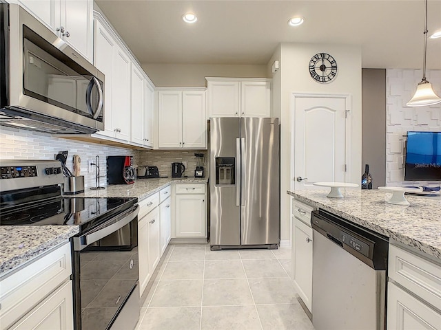 kitchen with hanging light fixtures, stainless steel appliances, tasteful backsplash, white cabinetry, and light tile floors