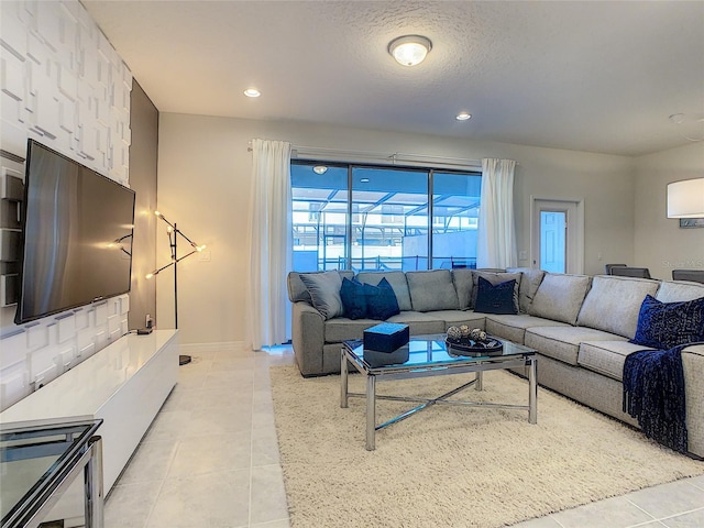 living room featuring a textured ceiling and light tile floors