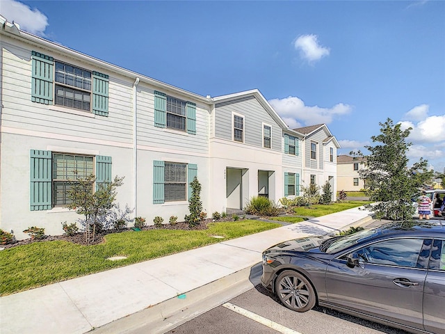 townhome / multi-family property featuring a front yard