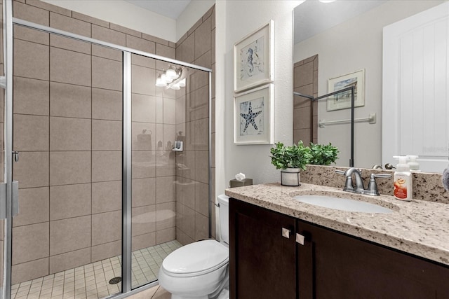 bathroom with vanity, an enclosed shower, and toilet