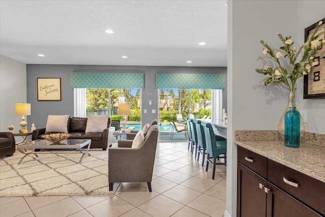 living room with a textured ceiling and light tile floors