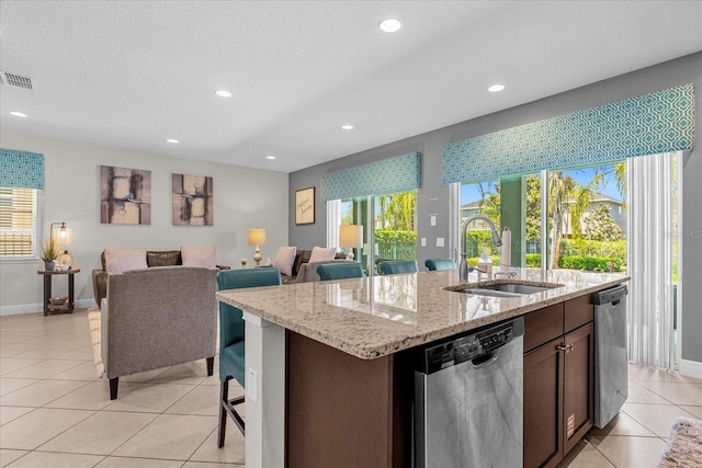 kitchen with sink, a center island with sink, light tile floors, and stainless steel dishwasher