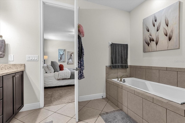 bathroom featuring a relaxing tiled bath, vanity, and tile floors