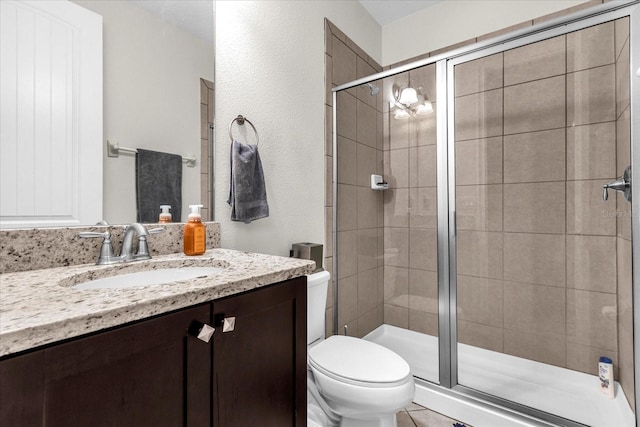 bathroom featuring walk in shower, vanity, and toilet