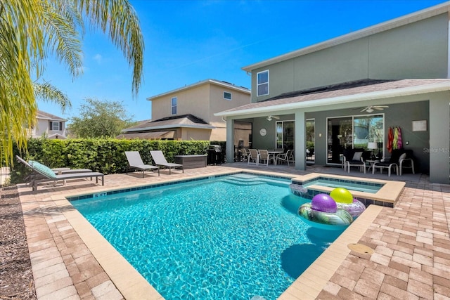 view of swimming pool featuring a patio area, ceiling fan, and an in ground hot tub