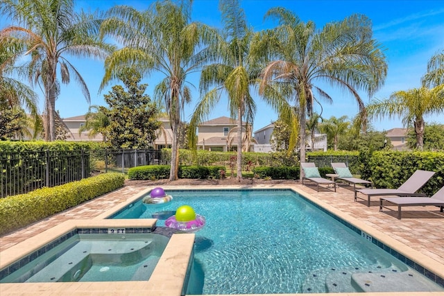 view of swimming pool with an in ground hot tub