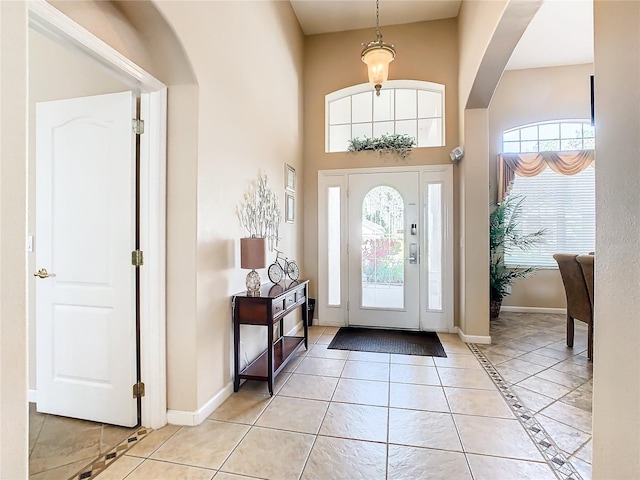 tiled entryway with plenty of natural light and a towering ceiling